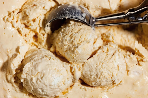 Una bola de helado de vainilla con una cuchara dentro.