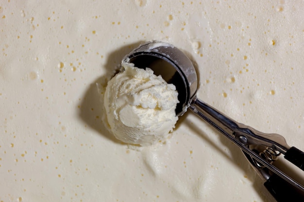 Una bola de helado de vainilla con una cuchara encima.