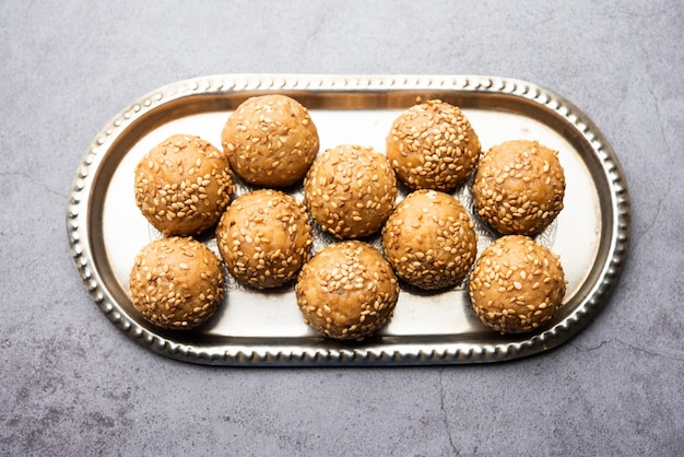 Bola de jaggery de semillas de sésamo o til ke laddo y tilgul o til gul laddu servido en un tazón para el Festival Makar Sankranti en la India