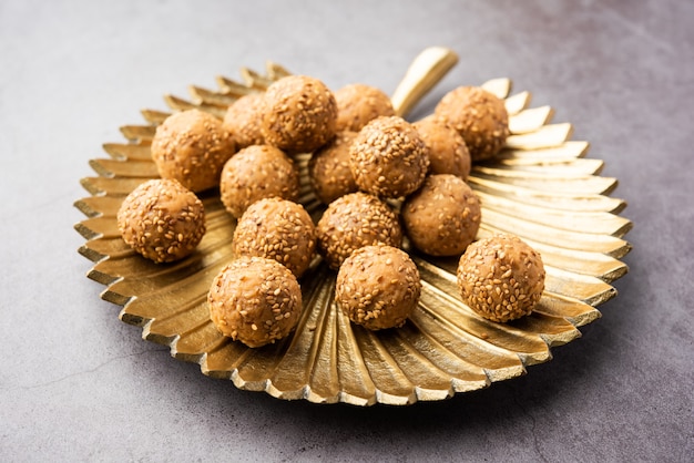 Bola de jaggery de semillas de sésamo o til ke laddo y tilgul o til gul laddu servido en un tazón para el Festival Makar Sankranti en la India