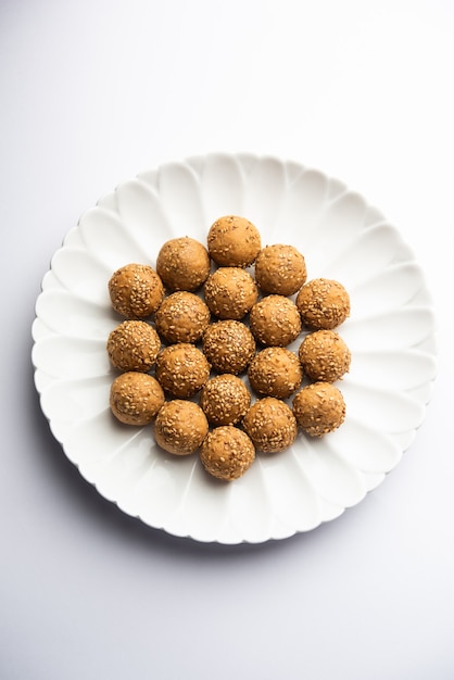 Bola de jaggery de semillas de sésamo o til ke laddo y tilgul o til gul laddu servido en un tazón para el Festival Makar Sankranti en la India