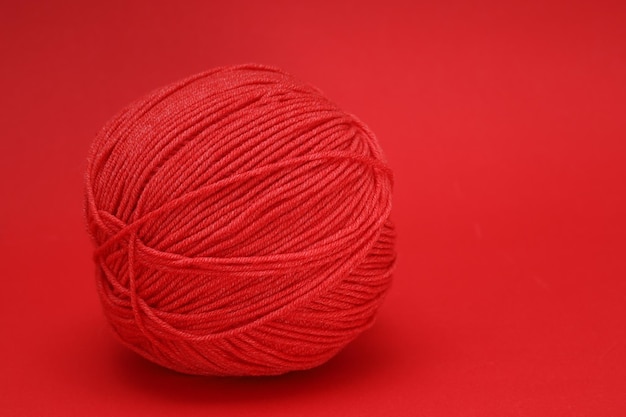 Bola de lana roja sobre fondo rojo. Foto de alta calidad