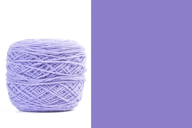 Foto bola de lana violeta sobre un fondo blanco y violeta con espacio de copia