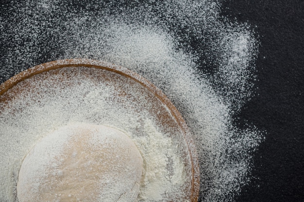 Bola de masa de pizza en una bandeja de madera