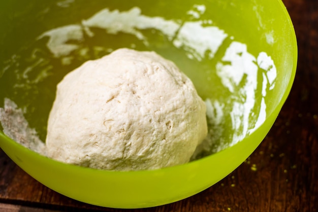 Bola de masa en recipiente de plástico Preparación de masa de levadura para hacer bases de pizza de pan