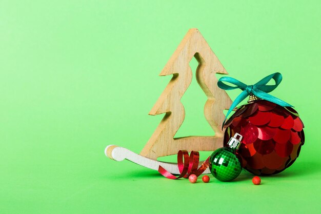 Foto bola de navidad con árbol decorativo de madera sobre fondo de color, adorno decorativo con lazo de cinta con espacio de copia