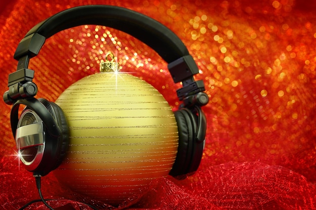 Bola de navidad con auriculares en fondo brillante