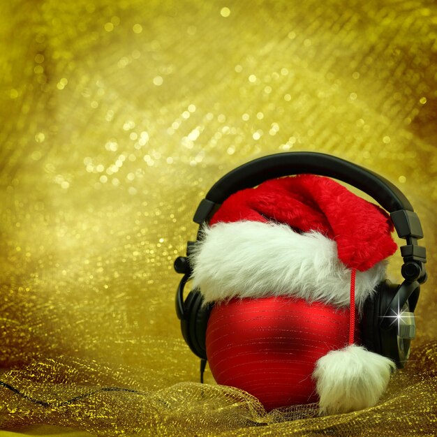 Bola de navidad con auriculares en fondo brillante