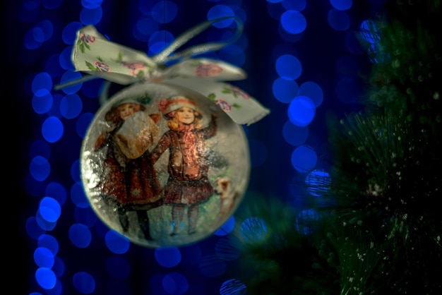 Foto bola de navidad cerca del árbol de navidad sobre un fondo azul neón