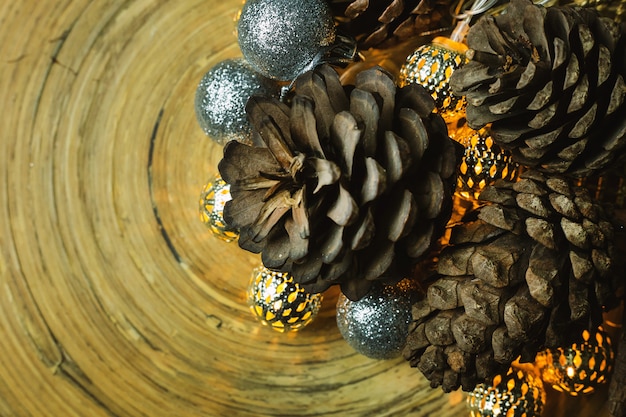 Foto bola de la navidad y conos del pino en el fondo de madera.