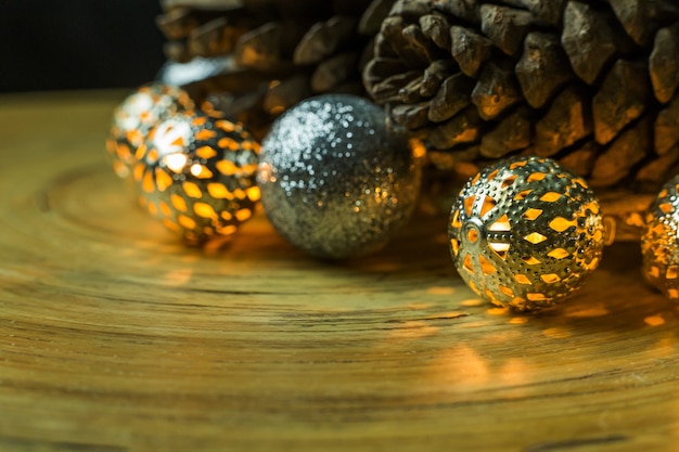 Bola de la Navidad y conos del pino en el fondo de madera.