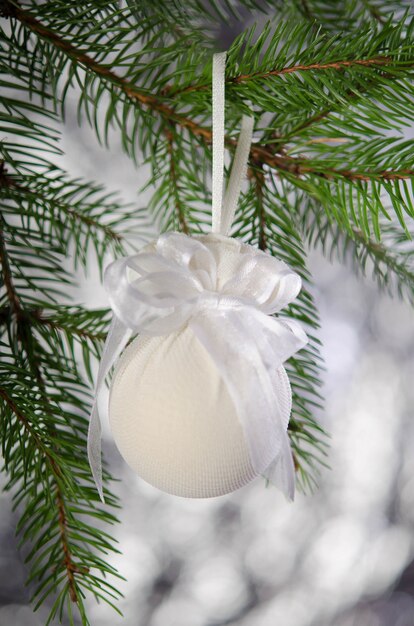 Bola de Navidad envuelta en una máscara médica en una rama de abeto. Decoración de año nuevo.