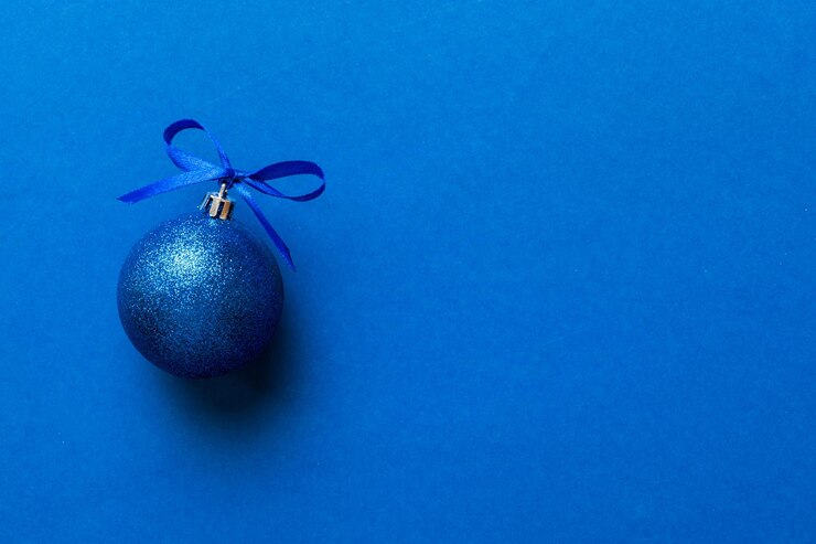 Foto bola de navidad en fondo de color decoración bauble con arco de cinta con espacio de copia