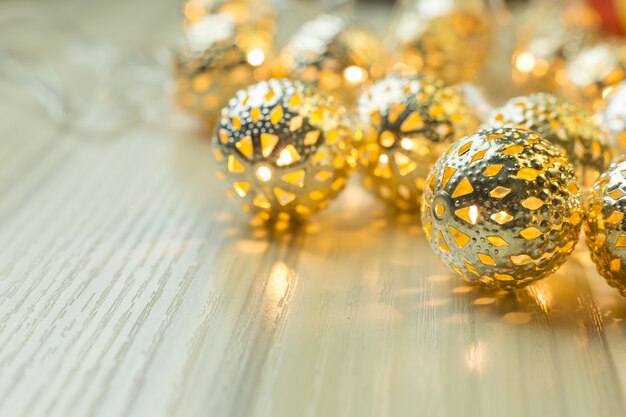 La bola de la Navidad del oro en el fondo de madera blanco de la tabla.