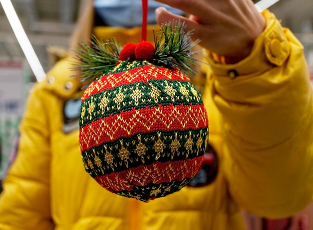 Bola de Navidad de punto Redgreen en mano primer plano Fondo de regalo de Navidad y Año Nuevo