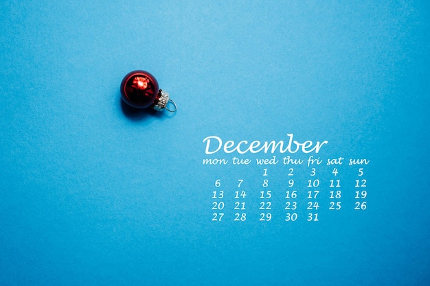 Foto bola de navidad roja sobre fondo azul calendario