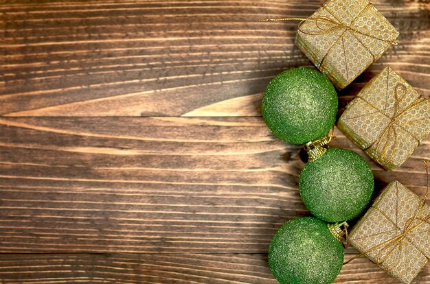 Bola de Navidad verde Caja de regalo dorada sobre fondo de madera