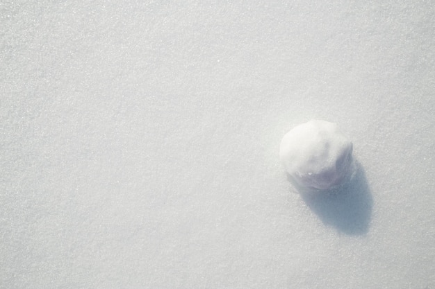 Bola de nieve sobre un fondo de nieve blanca pura día soleado helado