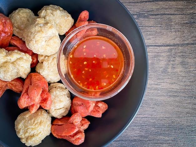 Bola de pescado frito y salchicha con salsa picante lista para comer