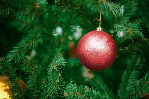 Bola roja en el árbol de Navidad. Decoraciones de año nuevo para las vacaciones.