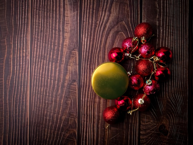 Bola vermelha de natal e caixa de presentes de ouro em uma mesa de madeira fundo de natal de feriados copiar espaço para texto ou design vista de cima