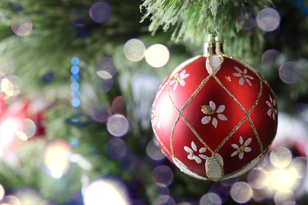 Bola vermelha fechada em uma árvore de Natal com um lindo bokeh trinkets de Natal feriados de inverno