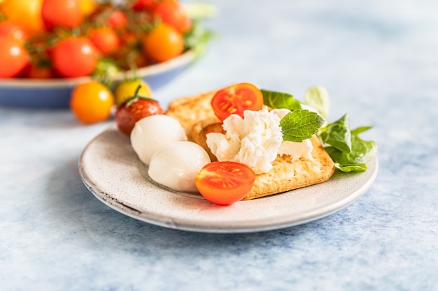 Bolachas com salada de tomate cereja e mussarela