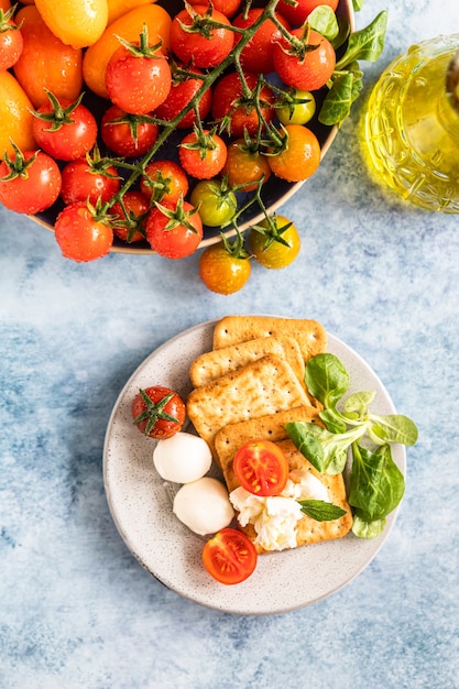 Bolachas com salada de tomate cereja e mussarela