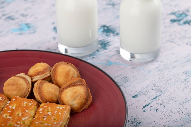 Bolachas doces com bolinhos em forma de nozes e jarras de leite.
