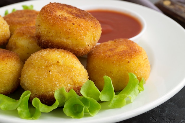 Bolas à milanesa de batata frita com molho de tomate