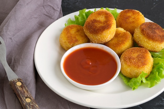 Bolas à milanesa de batata frita com molho de tomate