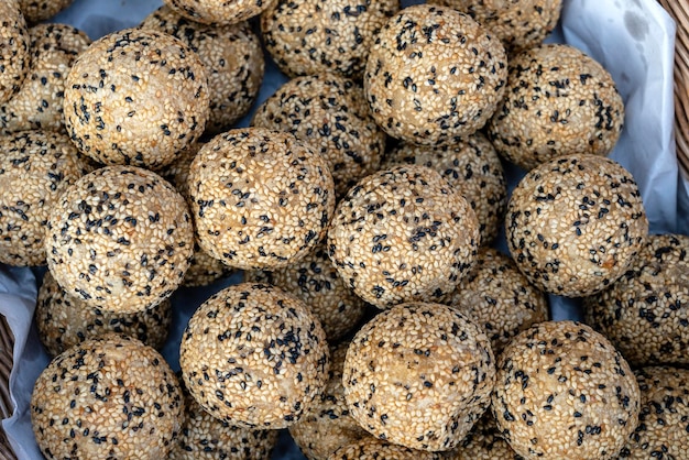 Bolas de arroz de coco con semillas de sésamo es un postre tradicional tailandés hecho de harina de arroz y leche de coco en el mercado de comida callejera en Tailandia