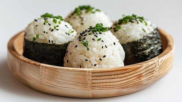 Las bolas de arroz recubiertas de algas marinas o nori se llaman onigiri y se sirven en un cuenco de madera.