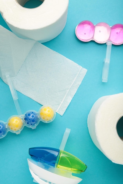 Bolas de baño y papel higiénico sobre fondo azul Limpie la taza del inodoro con bolas de limpieza y refrescantes