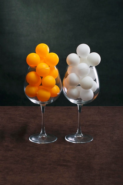Bolas blancas y anaranjadas en dos vasos grandes