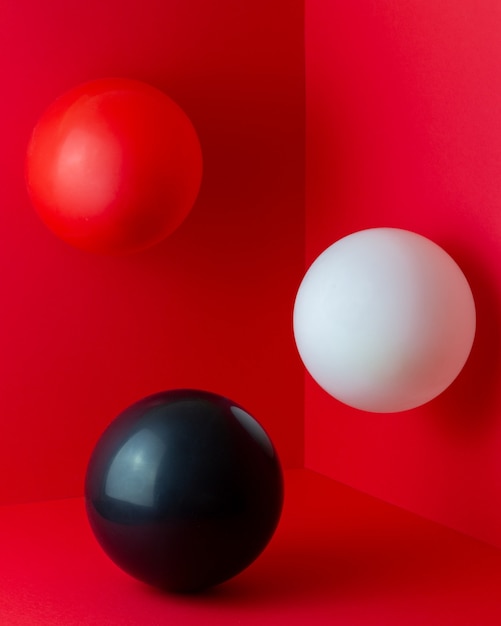 Bolas blancas, rojas, negras sobre un fondo rojo. Composición abstracta.