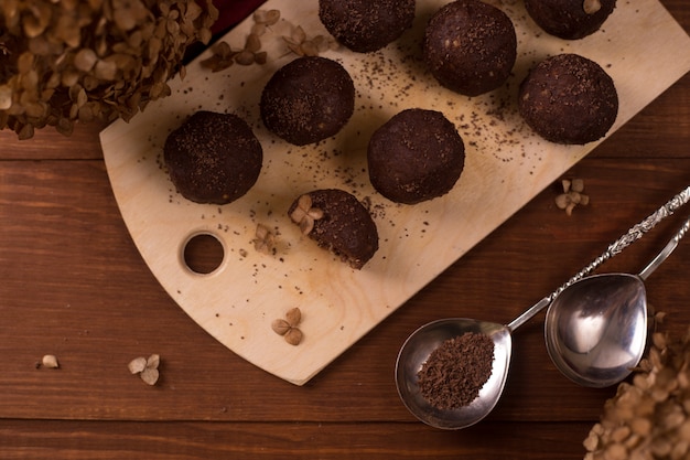 Bolas de cacao, tortas de trufas de chocolate a bordo en la mesa de madera