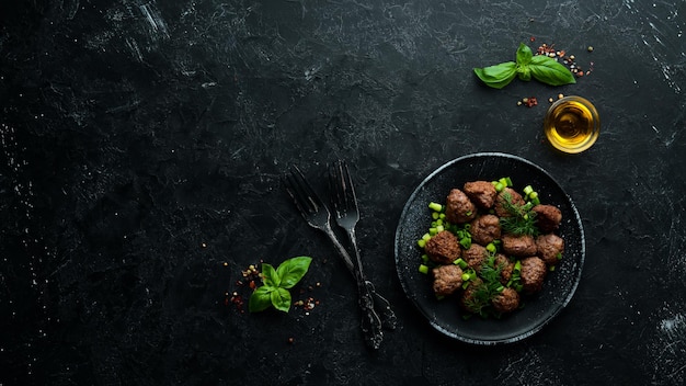 Bolas de carne al horno con cebolla en un plato negro Vista superior Espacio de copia libre