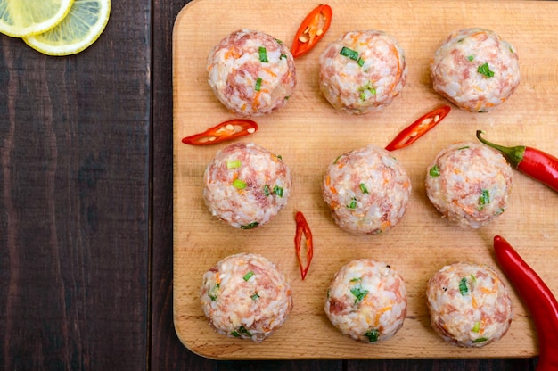 Bolas de carne cruda listas para cocinar en una tabla de cortar La vista superior