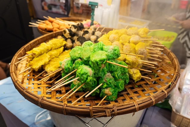 Bolas de carne y pescado de comida callejera asiática en brochetas