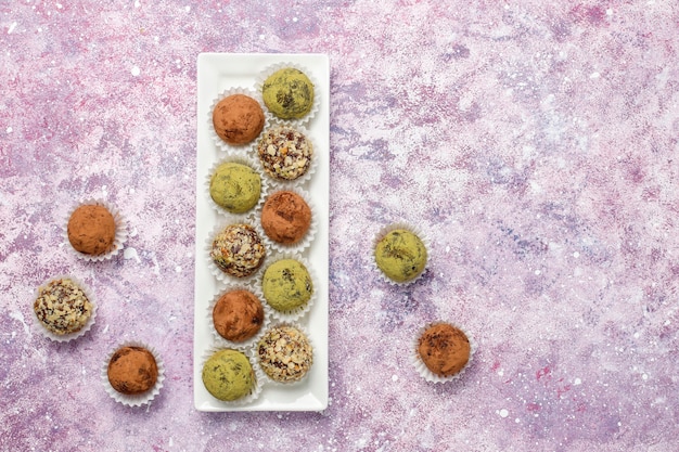 Bolas caseras de trufa vegana saludable de energía cruda con dátiles y nueces, polvo de matcha, cacao en polvo