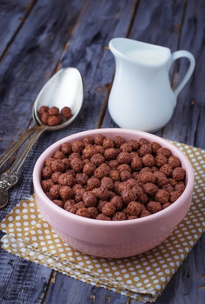 Bolas de cereal de chocolate en un tazón y leche.