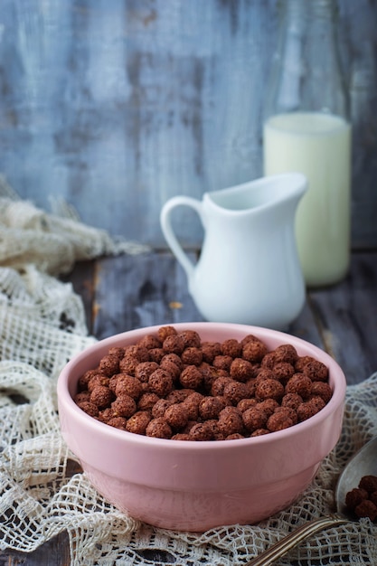 Bolas de cereal de chocolate en un tazón y leche.