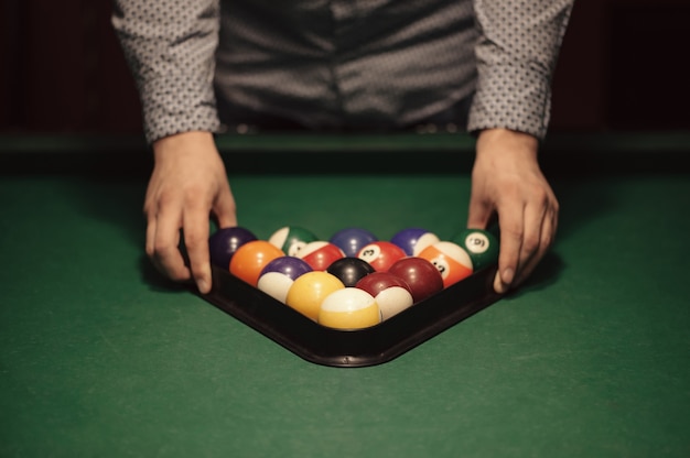 Foto bolas de colores de billar americano en triángulo en la mesa de billar y primer plano del jugador de billar