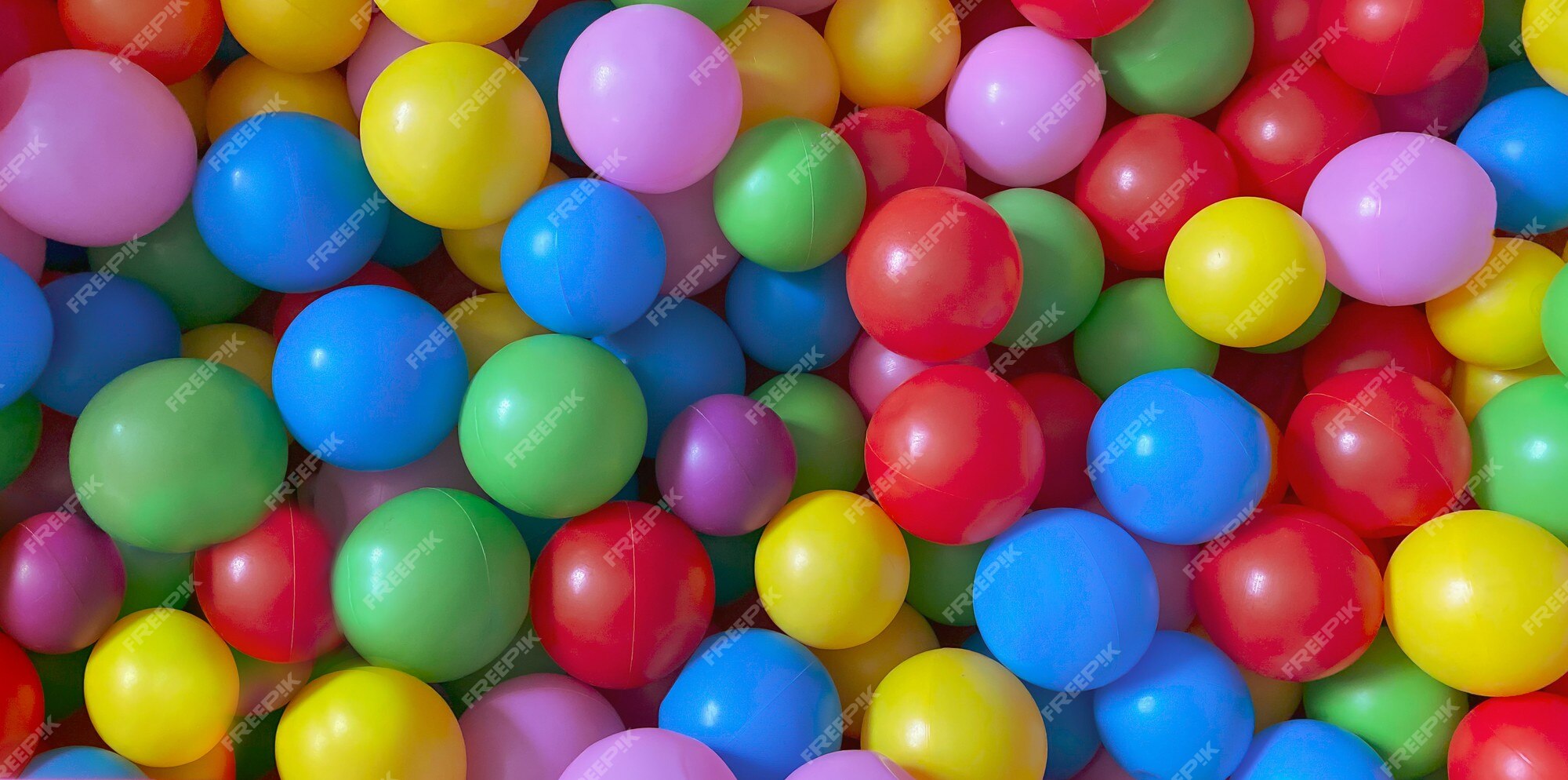 Bolas coloridas brilhantes para a piscina seca para jogos  infantis.brinquedos, desenvolvimento para crianças. fundo multicolorido  brilhante.