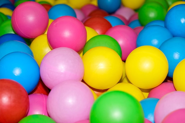 Bolas coloridas na piscina com bolas na sala de jogos