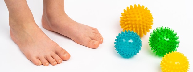 Bolas de agulhas coloridas para massagem e fisioterapia em um fundo branco com a imagem de crianças