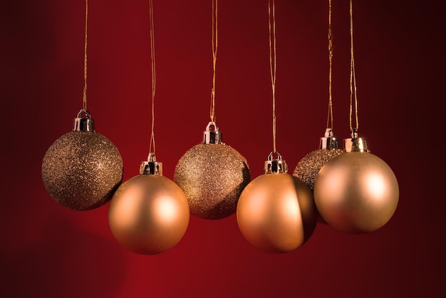 Bolas de árvore de natal douradas em um fundo vermelho escuro