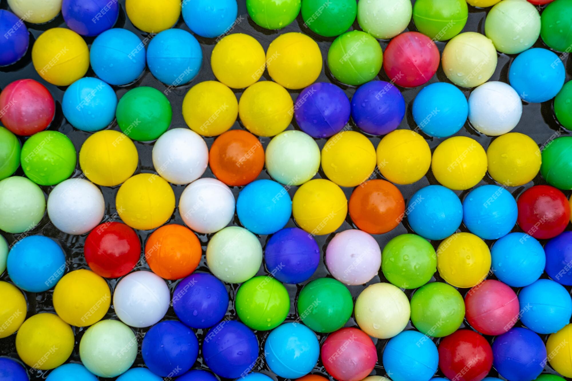 Bolas coloridas brilhantes para a piscina para jogos infantis.brinquedos  para crianças, entretenimento para crianças.use em catálogos de lojas  infantis, centros de entretenimento de publicidade. fundo multicolorido  brilhante