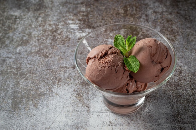 Bolas de chocolate de sorvete cremoso em uma xícara contra o fundo de uma mesa de pedra cinza